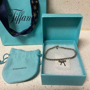 Authentic Tiffany & Co. bow bead bracelet, bag, jewelry duster, box, and ribbon.